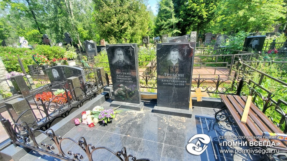 Участок с двумя гранитными памятниками и тёмной облицовкой до начала работ